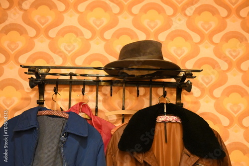 Bild auf Leinwand 1960er Jahre-Stil: alte schmiedeeiserne Garderobe mit Hut und Jacken auf altmodi