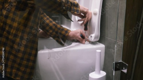 Caucasian workman fixing the bathroom toilet photo