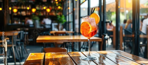 Aperol spritz cocktail on wooden table in cafe photo