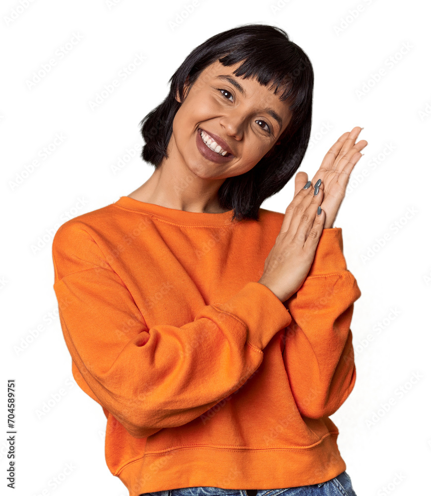 Young Hispanic woman with short black hair in studio feeling energetic and comfortable, rubbing hands confident. Young Hispanic woman with short black hair in studio feeling energetic and comfortable, rubbing hands confident.