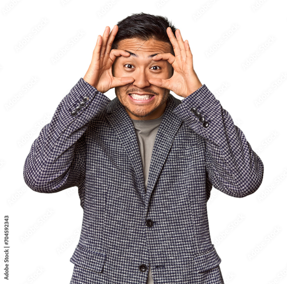 Young Chinese man in studio background keeping eyes opened to find a success opportunity. Young Chinese man in studio background keeping eyes opened to find a success opportunity.