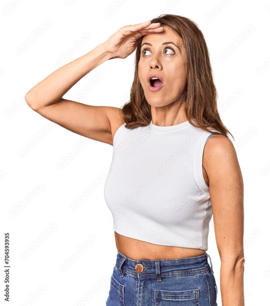 Middle-aged woman portrait in studio setting looking far away keeping hand on forehead. Middle-aged woman portrait in studio setting looking far away keeping hand on forehead.