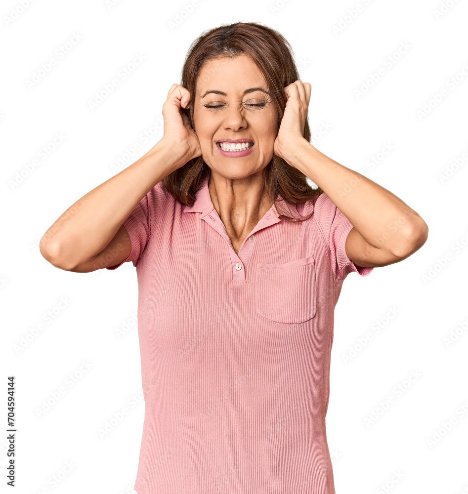 Middle-aged woman portrait in studio setting covering ears with hands. Middle-aged woman portrait in studio setting covering ears with hands.