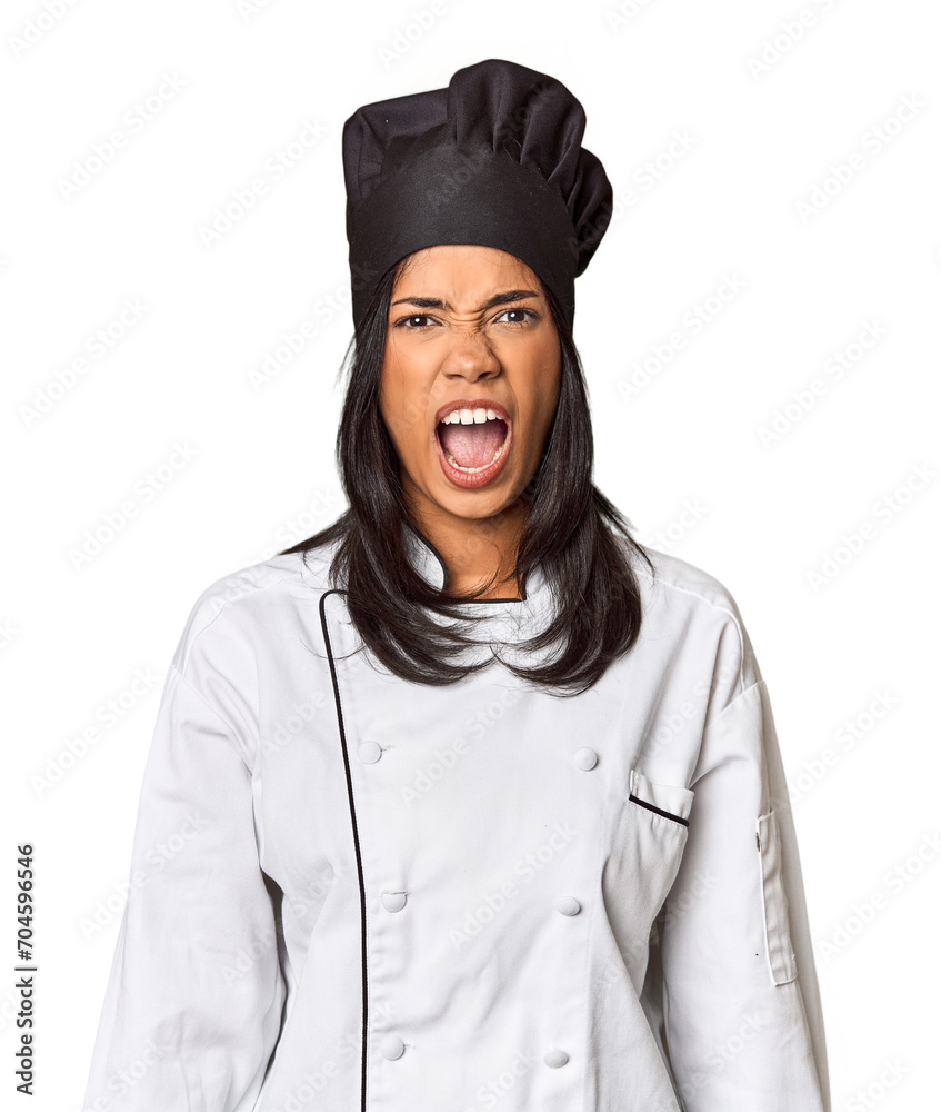 Young Filipina chef with cooking hat in studio screaming very angry and aggressive. Young Filipina chef with cooking hat in studio screaming very angry and aggressive.