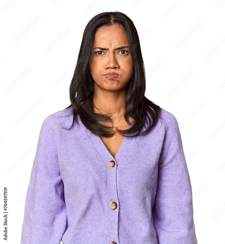 Young Filipina with long black hair in studio blows cheeks, has tired expression. Facial expression concept. Young Filipina with long black hair in studio blows cheeks, has tired expression. Facial expression concept.