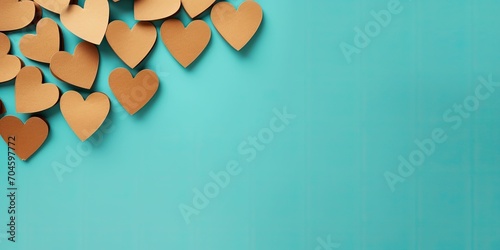 Hearts made of brown kraft paper on a turquoise background, Valentine's Day card background 