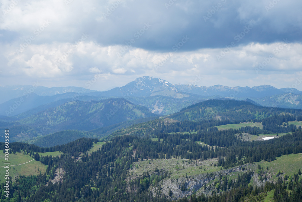 Idyllic panoramic view: Small green hills and steep snowy mountains in Ötscherland, Lower Austria