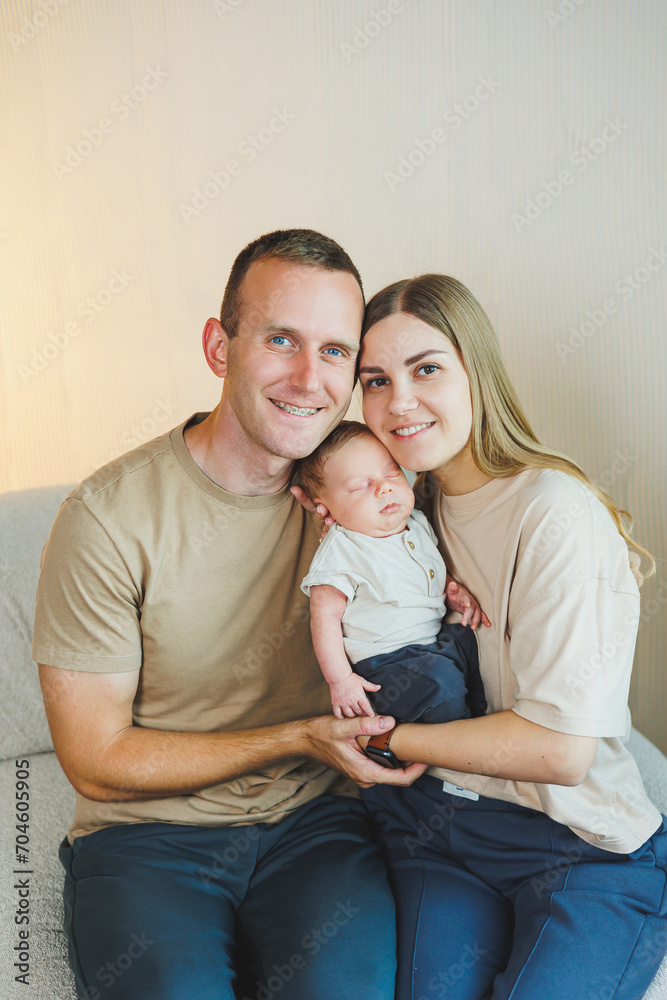 Happy young family with a newborn baby. Beautiful mother and father kissing their child. Parents and smiling child in arms, isolated over white background. Happy young family with a newborn baby. Beautiful mother and father kissing their child. Parents and smiling child in arms, isolated over white background.