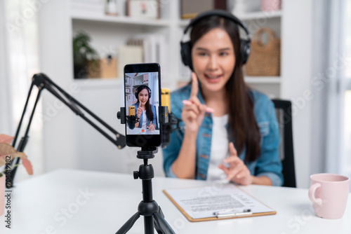 Host channel of young beautiful Asian wearing jeans creative broadcaster talking in online broadcast explaining to promote marketing or consultant in daily life with listener at studio. Stratagem.