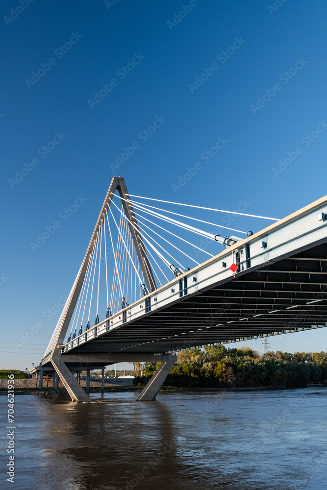 Low angle view of suspension bridge towering over river Low angle view of suspension bridge towering over river