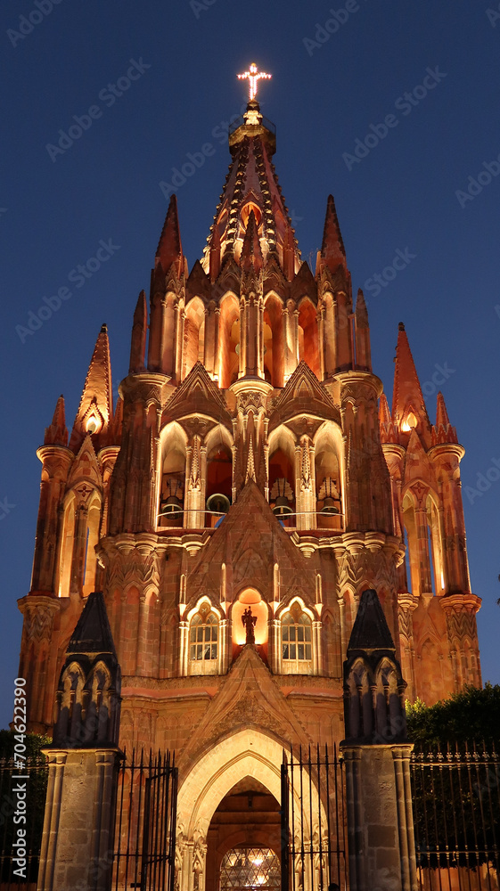 Fototapeta premium The fascinating front facade of the church/cathedral Parroquia de San Miguel Arcangel in San Miguel de Allende at night, Mexico