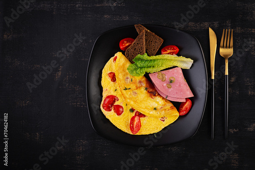 Omelette with tomatoes and cheese with bread and mortadella sausage. Top view