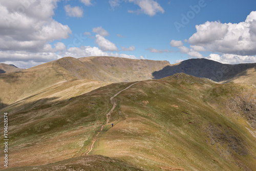 The summit of Fairfield seen as a hiker ascends Heron Pike on the Fairfield Horseshoe, Lake District, UK photo