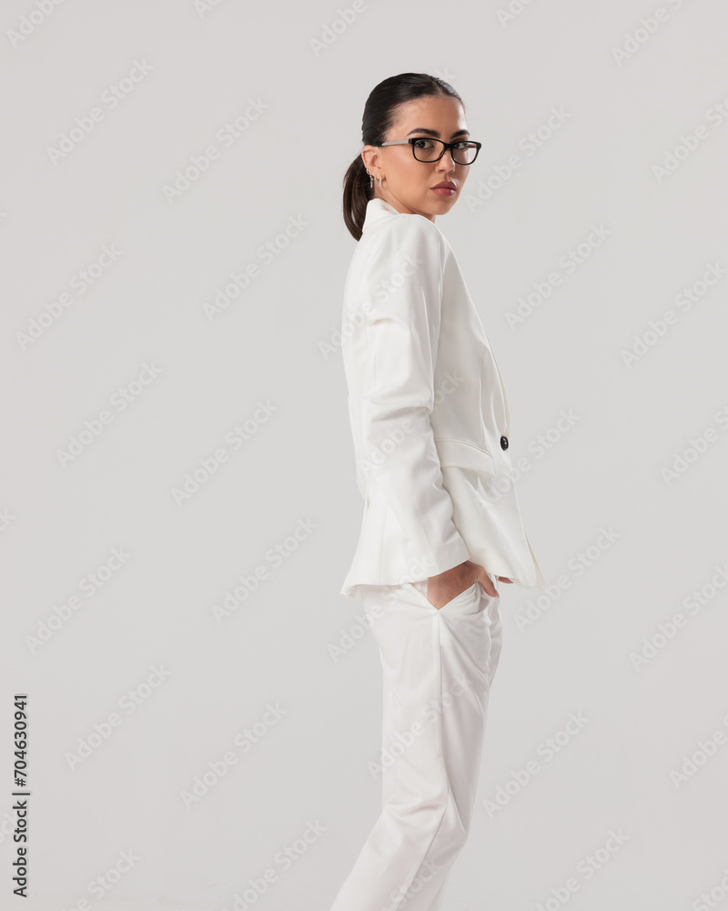 side view of elegant fashion woman with glasses holding hands in pockets side view of elegant fashion woman with glasses holding hands in pockets