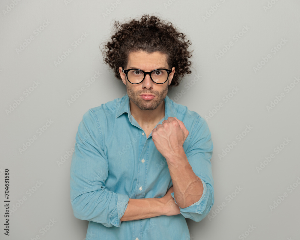 angry young man with glasses being upset and showing fist angry young man with glasses being upset and showing fist