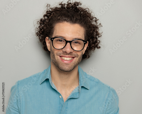 close up of sexy man with curly hair looking forward and smiling photo