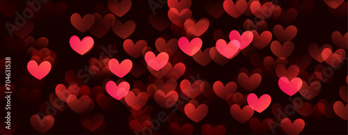 Red hearts valentine day defocused bokeh lights on a black background.