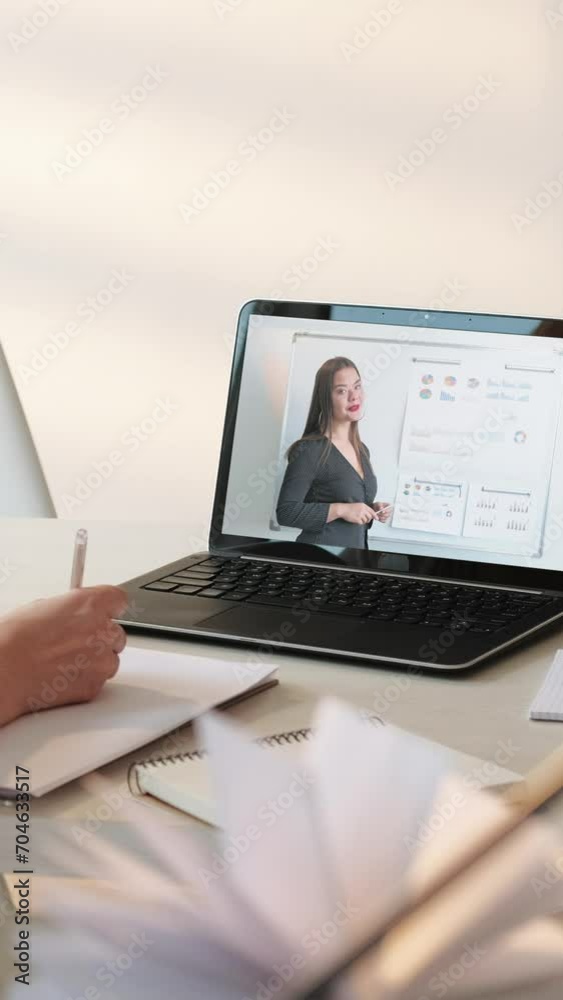 Vertical video. Online presentation. Virtual conference. Business woman at remote meeting with employee on laptop with statistics report charts graphs hand writing notes at home. Vertical video. Online presentation. Virtual conference. Business woman at remote meeting with employee on laptop with statistics report charts graphs hand writing notes at home.