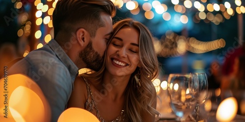 Man kissing woman on the cheek in the restaurant, romantic valentine’s day dinner date, with bokeh lights photo