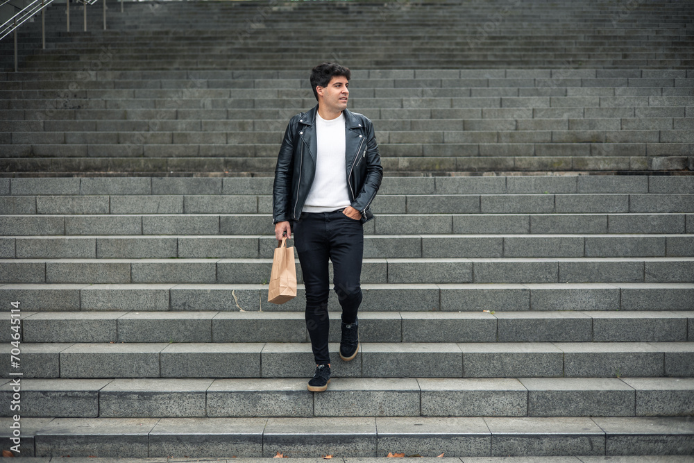 Obraz premium dark-haired boy in leather jacket going down stairs