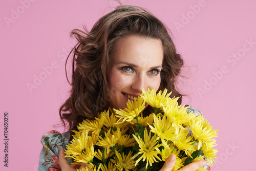 smiling woman in floral dress on pink photo