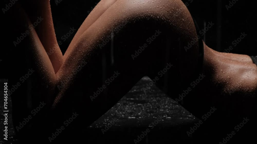 Beautiful female ass with water drops. Water is sprayed on a woman's body.
