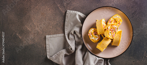Tortilla rolls with salad of sausages, eggs, cheese and herbs on a plate top view web banner