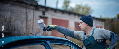 Canvas Print Master car painter paints a car with a spray gun