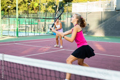 Active young tennis girl dressed in pink t-shirt and skirt on court ready for playing and training. Sport and healthylife concept photo