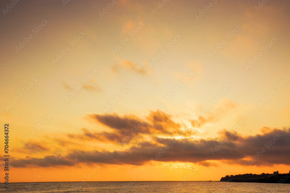 golden sunrise at the black sea. fluffy clouds cover the sun above horizon. good weather forecast on summer vacation in bulgaria