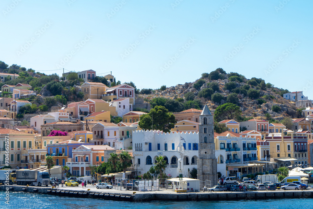 Clock Tower and houses of island Symi or Simi, Greek mountainous island and municipality, part of Dodecanese island chain. Harbor town of Symi and adjacent upper town Ano Symi