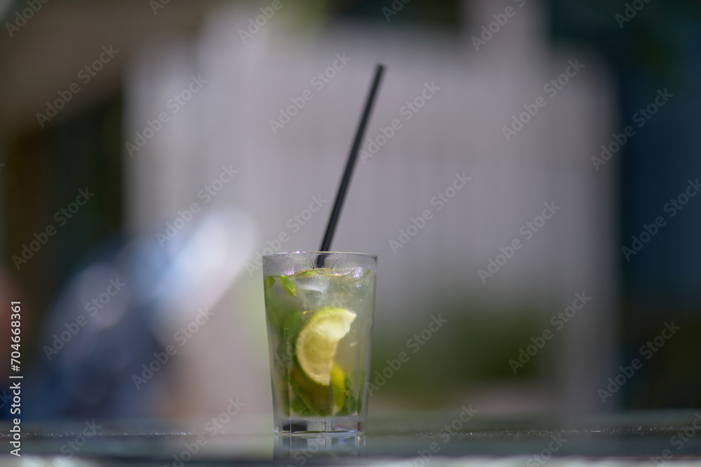 Refreshing green lemonade in a glass on the table against the background of nature. Freshly squeezed drinks with ice. Lemonade with lemon, mint lime and herbs Refreshing green lemonade in a glass on the table against the background of nature. Freshly squeezed drinks with ice. Lemonade with lemon, mint lime and herbs
