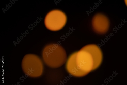 Abstract warm blurred lights bokeh on black background. © Dmytro