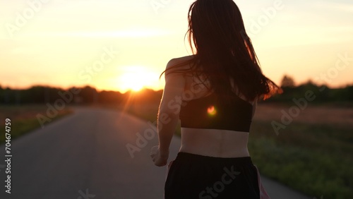 silhouette sports girl running legs along road sunset, summer thailand, jogger, street evening, warming up before training, endurance training, marathon race, young asian women training outdoors photo