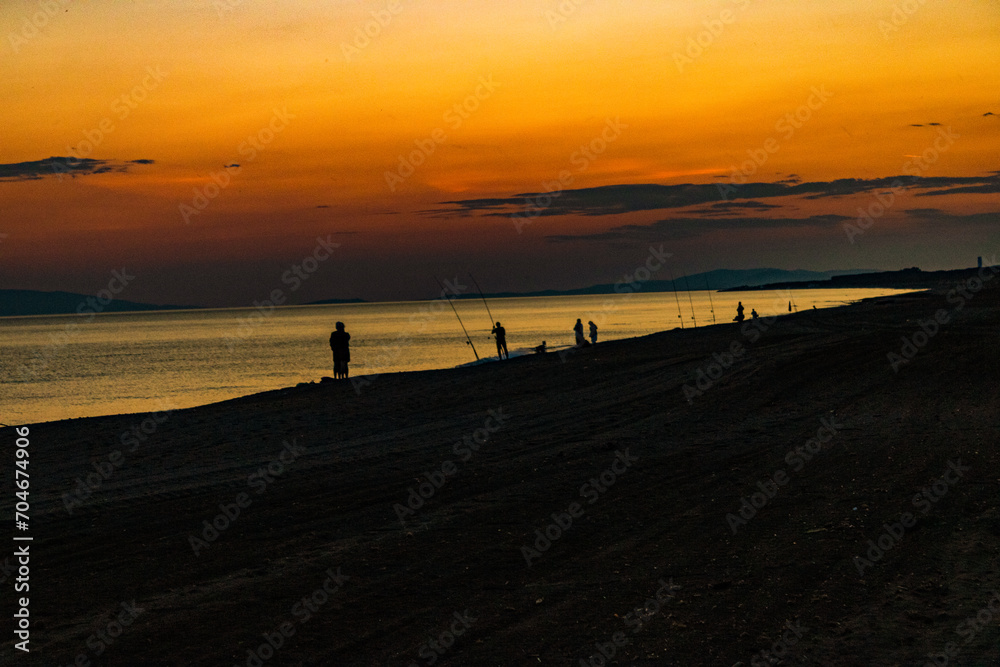 sunset with fishermen on the beach
