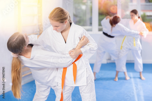 Girls athletes in pair conduct training battle in oriental fighting technique. School of martial arts. Strengthening strength of mind and body
