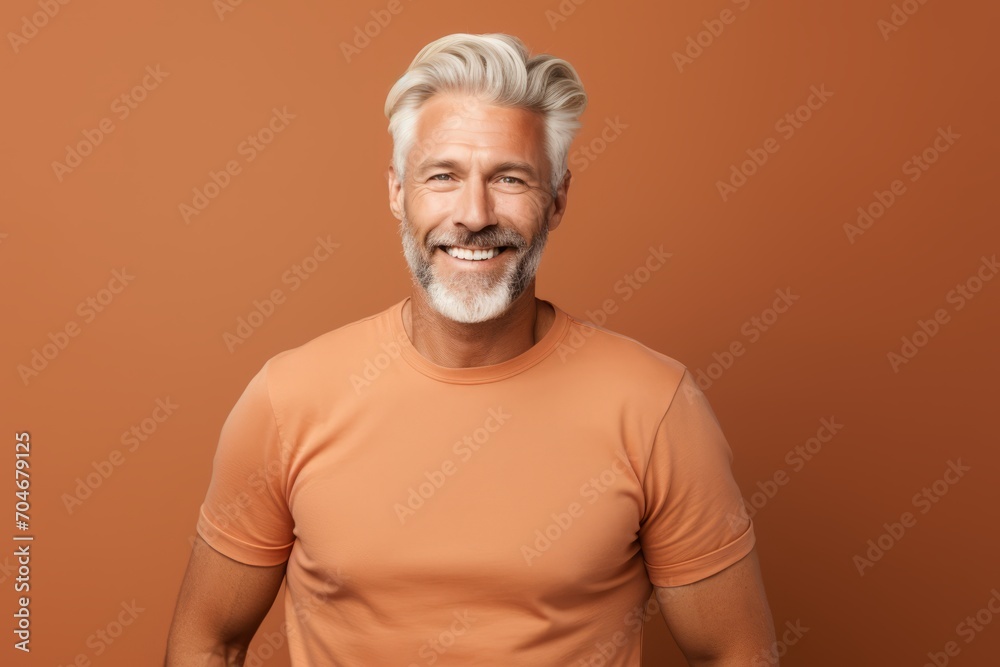 Handsome mature man in casual t-shirt on brown background Handsome mature man in casual t-shirt on brown background