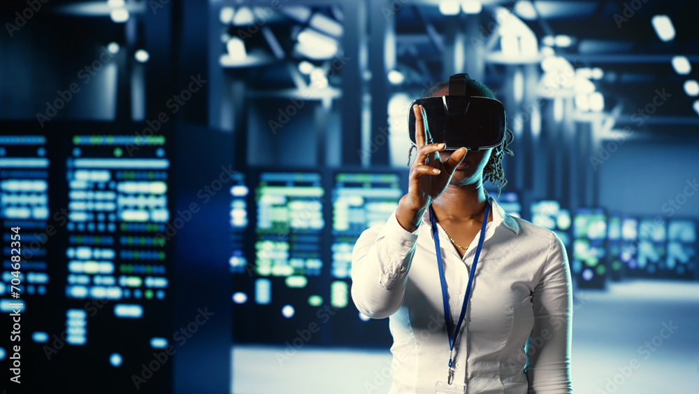 African american trained admin immersed in virtual reality at data center, doing units maintenance. Capable expert using VR headset to optimize servers performance, checking operations