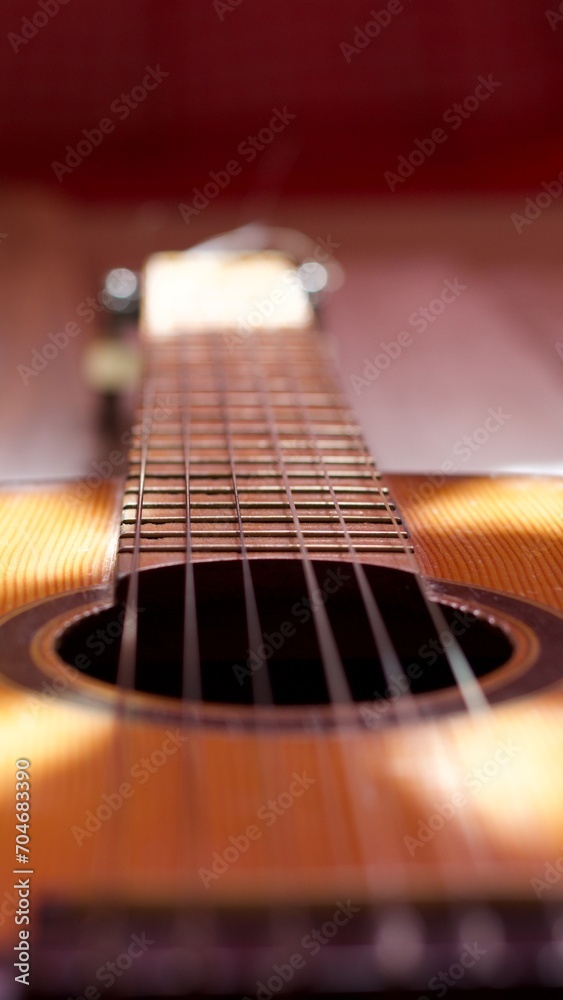 Fototapeta premium neck and headstock of an acoustic guitar on aged white wood, romantic, melancholic, solitary, thoughtful, reflective concept.