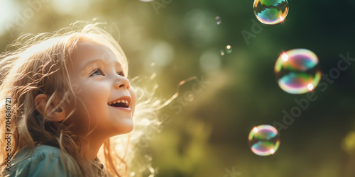 The girl looks at the soap bubbles with delight