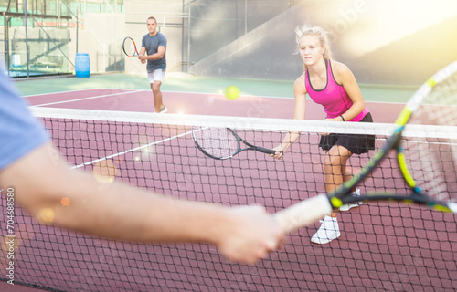 Active sports woman making serve while playing tennis. Racket sport training outdoors