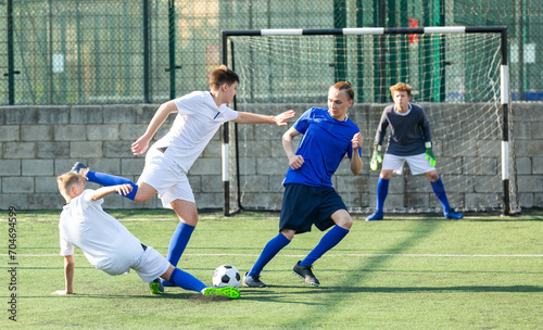 Junior football teams having scrimmage and struggling for ball © JackF
