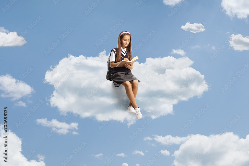 Girl in a school uniform sitting on a cloud and writing homework Girl in a school uniform sitting on a cloud and writing homework