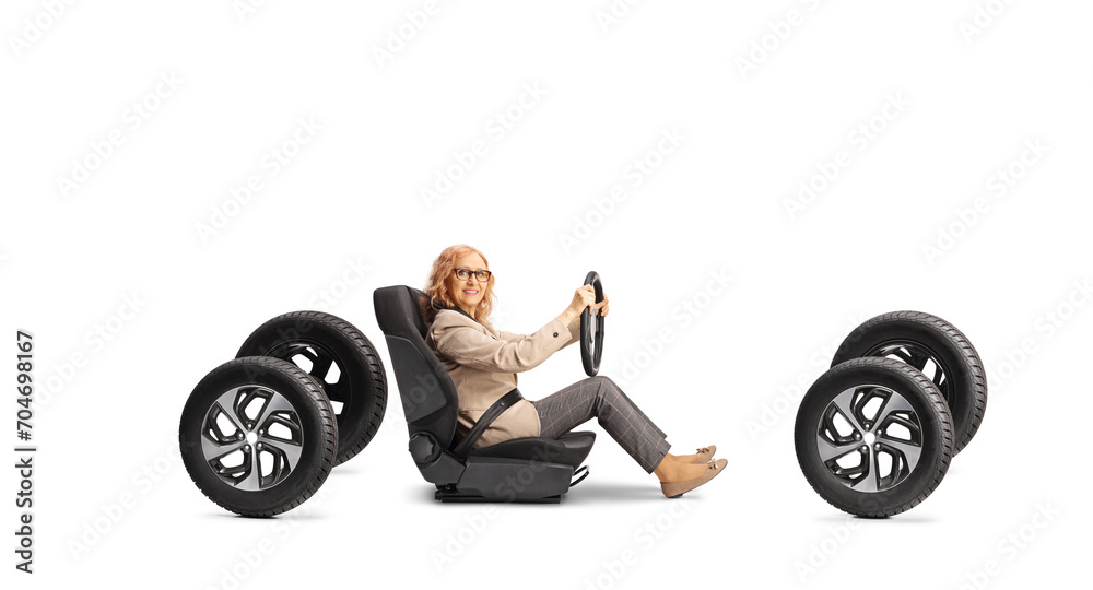 Middle aged woman sitting in a car seat on four tires and holding a steering wheel