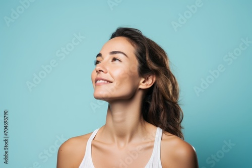 Portrait of a beautiful young woman with clean fresh skin on blue background