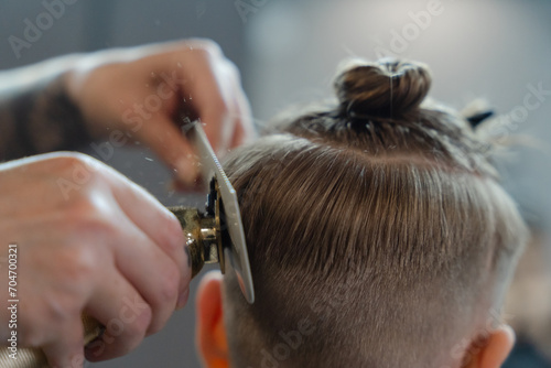 Haircut in progress: a barber working on a young boy's hair in a barbershop