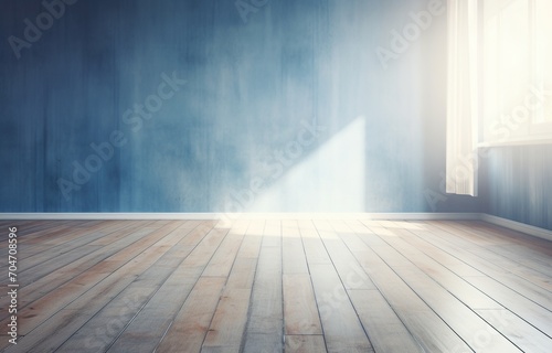 Sunlight shining through a window into an empty room with blue walls and a wooden floor