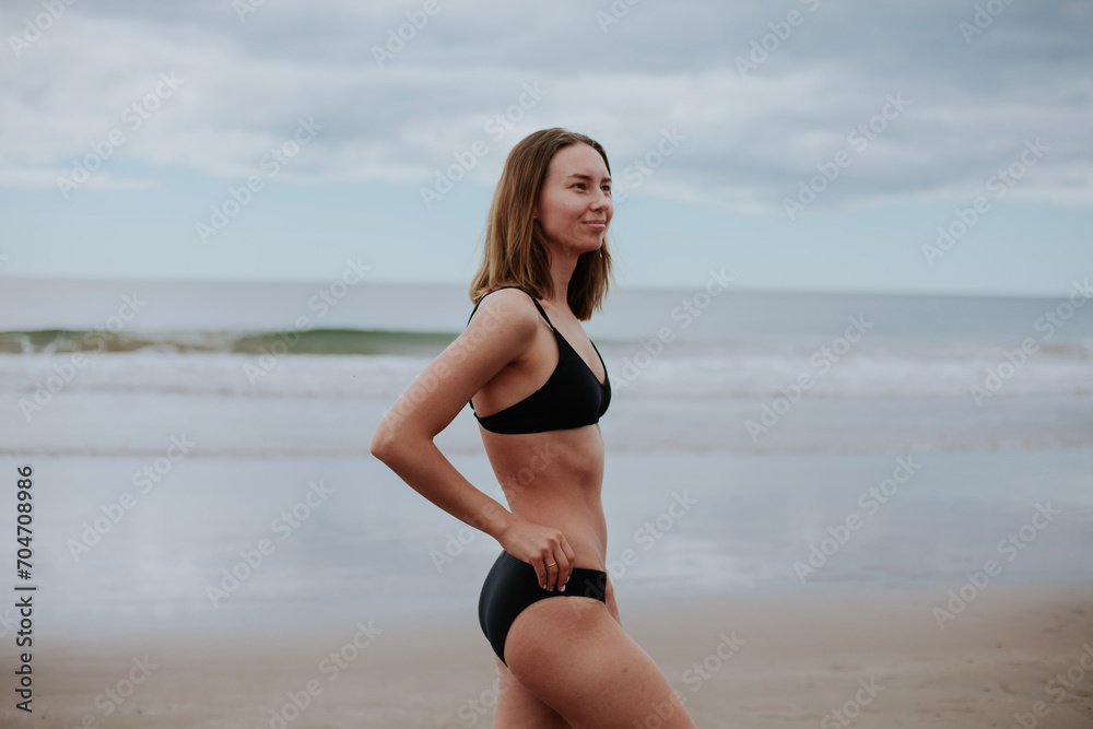 Beautiful ukrainian woman in black bikini on tropical beach. Portrait of happy young woman smiling at sea. Brunette tanned girl in swimwear enjoying and walking on beach. Beautiful ukrainian woman in black bikini on tropical beach. Portrait of happy young woman smiling at sea. Brunette tanned girl in swimwear enjoying and walking on beach.