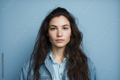 Portrait of a beautiful young woman looking at camera over blue background