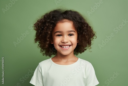 happy african american little girl with curly hair over green background